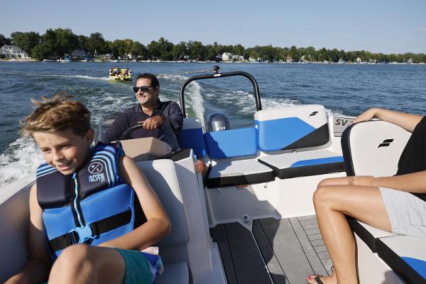 Family enjoying a ride on a 2025 Starcraft SV 16 OB boat on a sunny lake.
