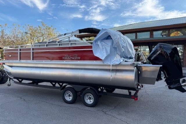2026 Sun Tracker Fishin' Barge 22 XP3 pontoon boat on trailer, parked outdoors.