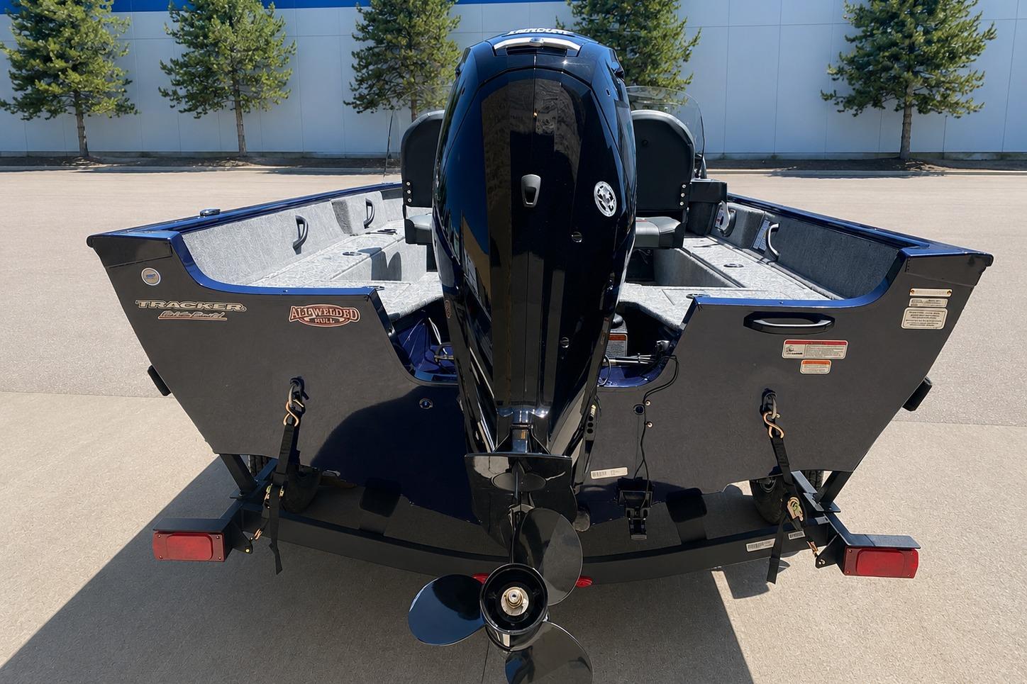 2026 Tracker Pro Guide V-16 SC boat, rear view with motor, parked outdoors.