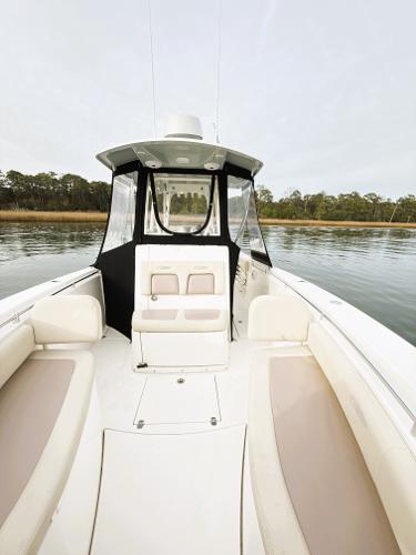 2016 Cobia 296 Center Console boat on calm water, featuring spacious seating and sleek design.