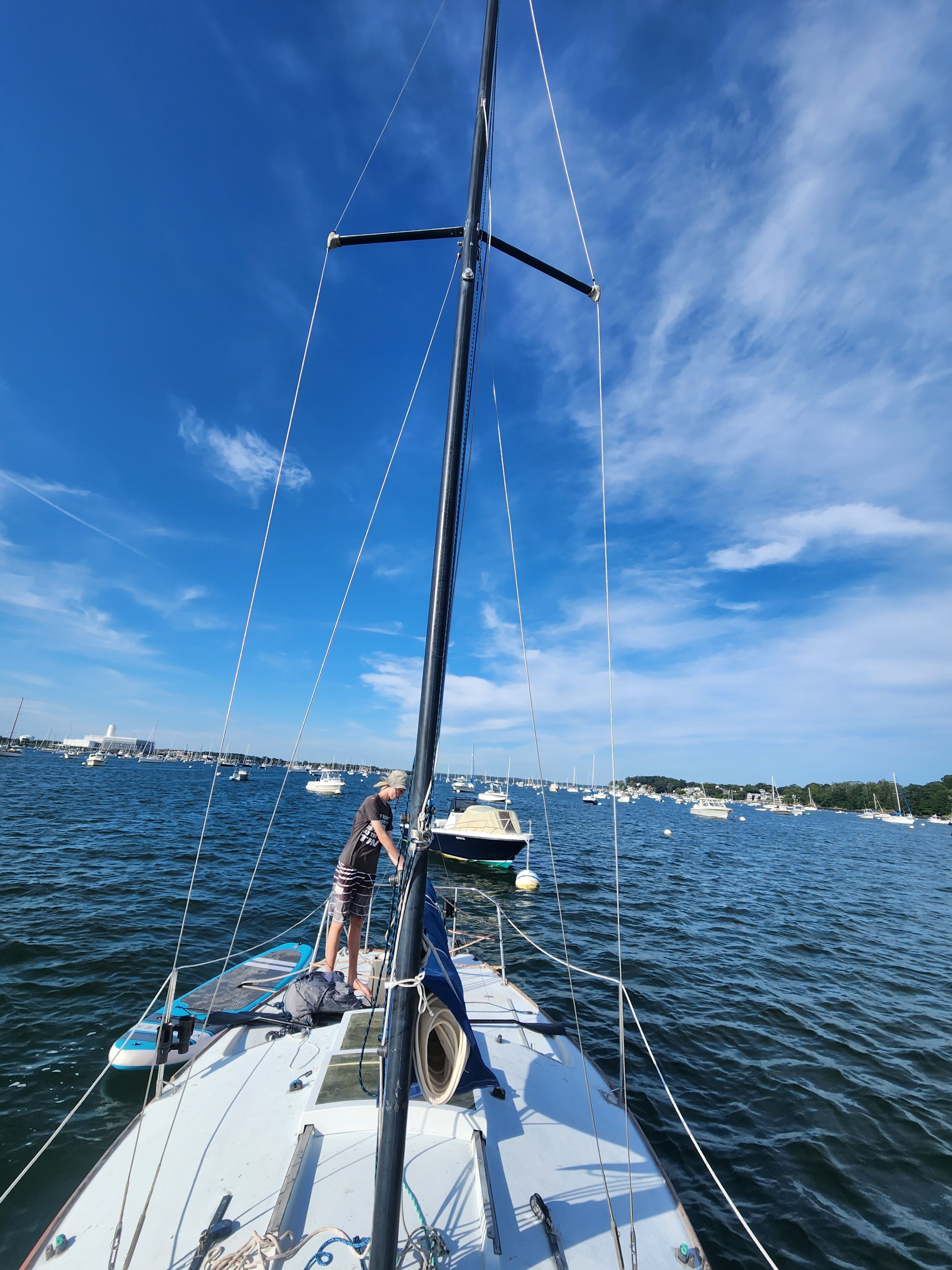 1978 J/24 sailboat on calm water with blue sky.