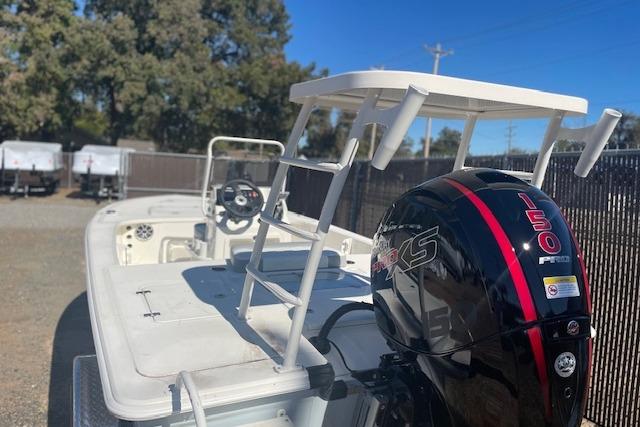 2026 Mako 18 Pro Skiff boat with 150 HP engine, parked outdoors.