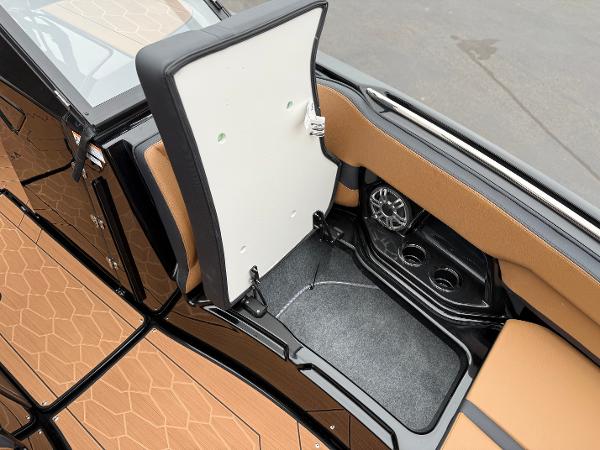 2025 Yamaha Boats 255XD interior storage compartment with cup holders and speaker.