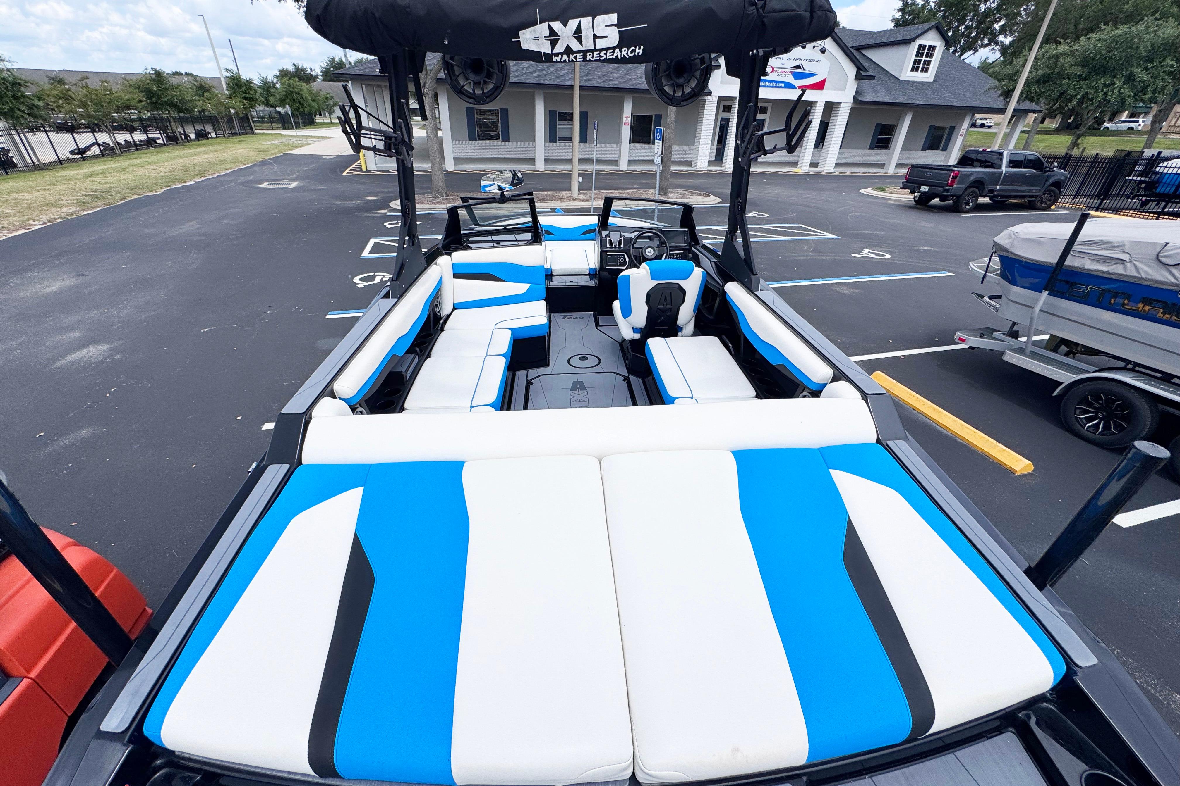 2022 Axis T220 boat with blue and white seating, parked in a lot.
