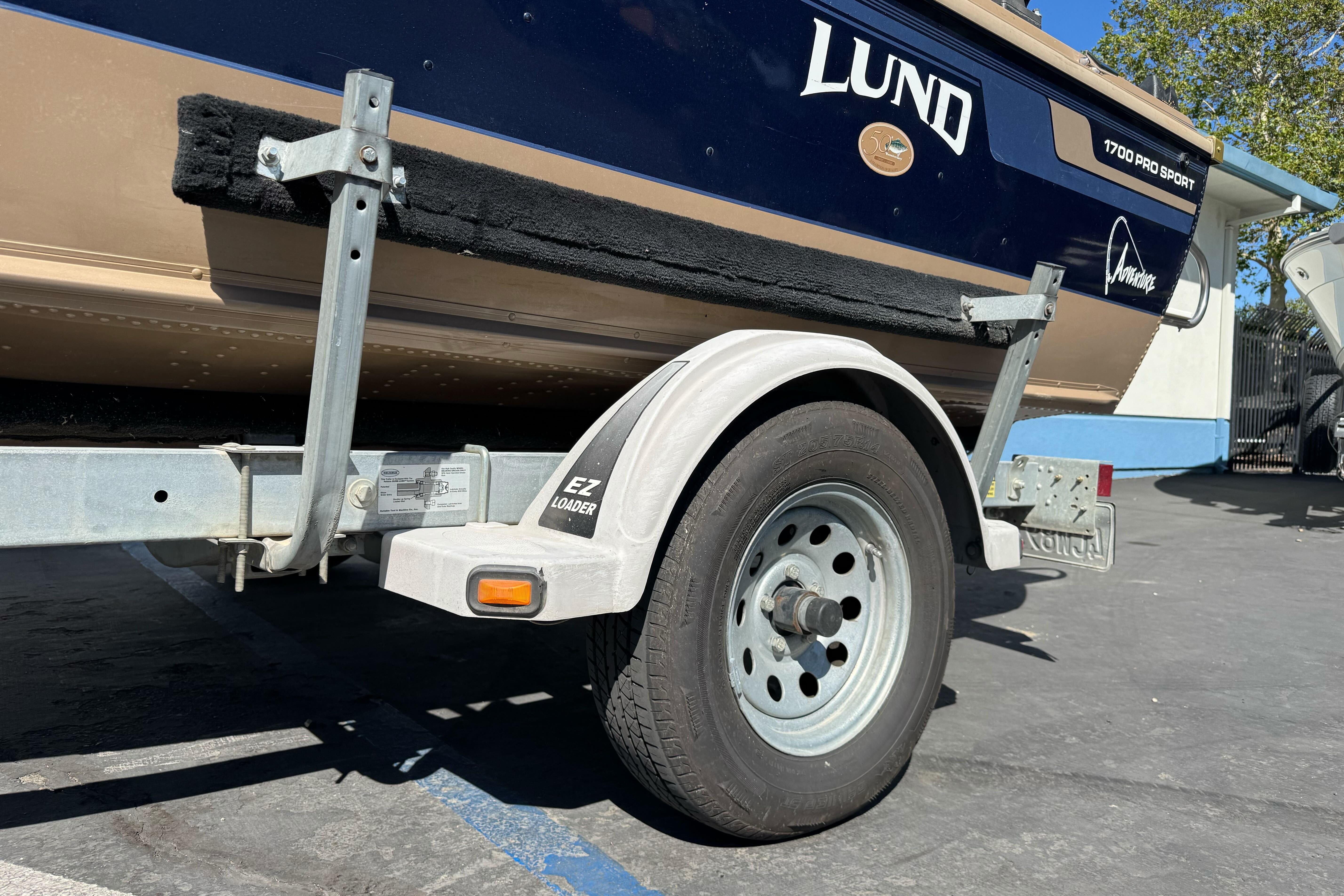 1998 Lund 1700 Pro Sport boat on EZ Loader trailer, parked outdoors.