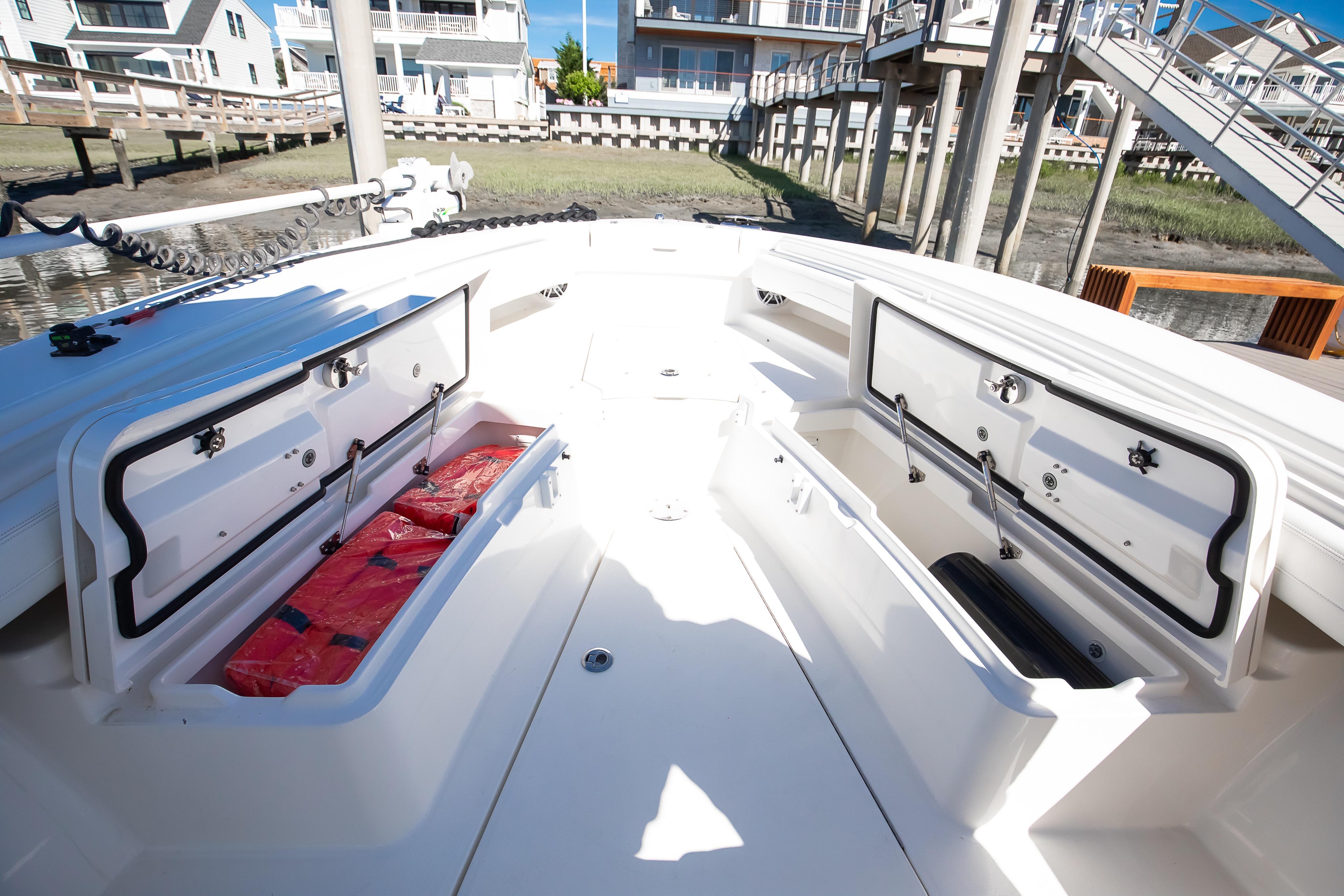 2022 Regulator 28 Forward Seating boat with open storage compartments, docked near waterfront homes.
