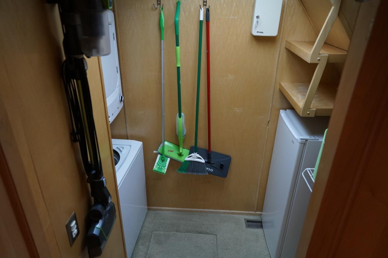 Laundry room in 2000 Stardust Cruisers houseboat with cleaning tools and appliances.