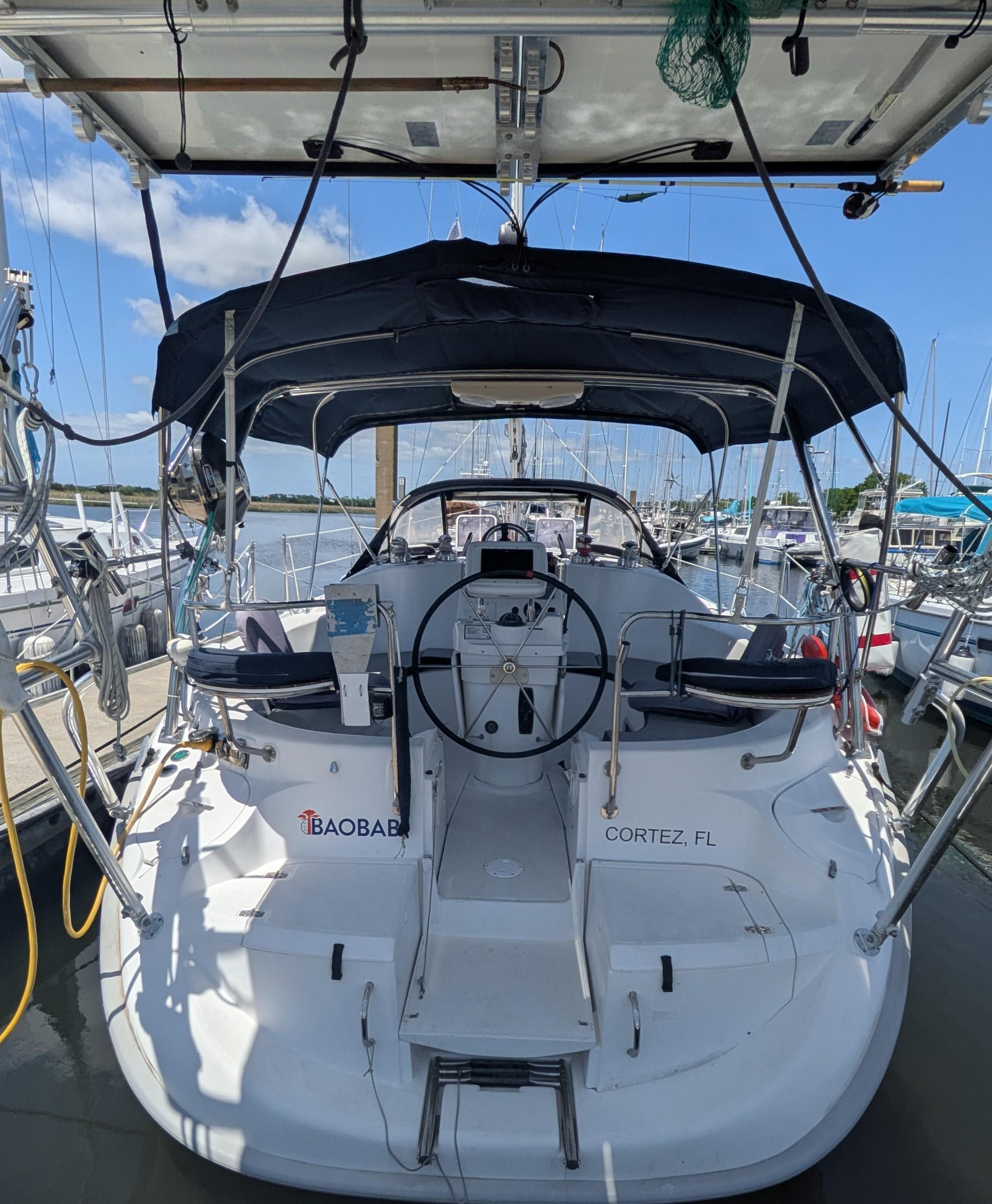 2001 Hunter 380 sailboat docked in Cortez, FL, featuring a spacious cockpit and steering wheel.