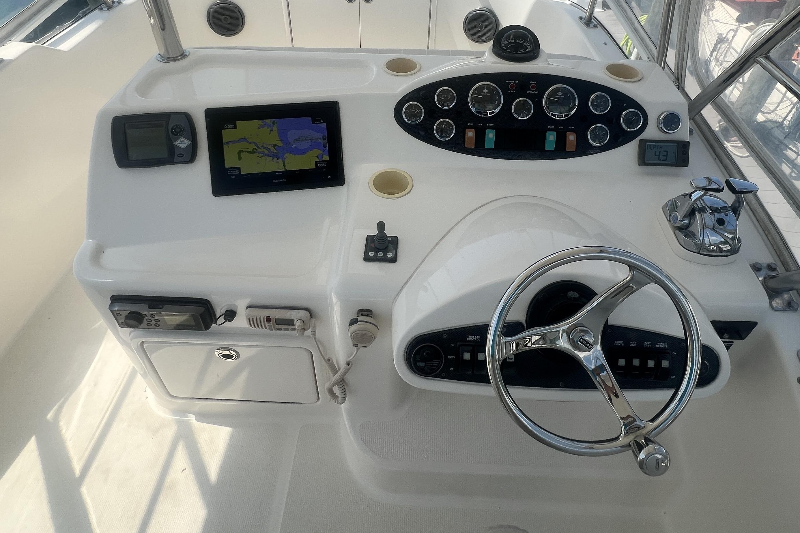 Helm of 2007 Riviera 33 Flybridge with navigation equipment and steering wheel.
