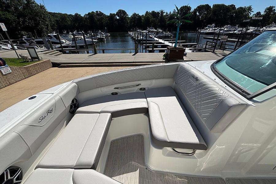 2027 Sea Ray SDX 230 Outboard boat interior with white seating at marina.