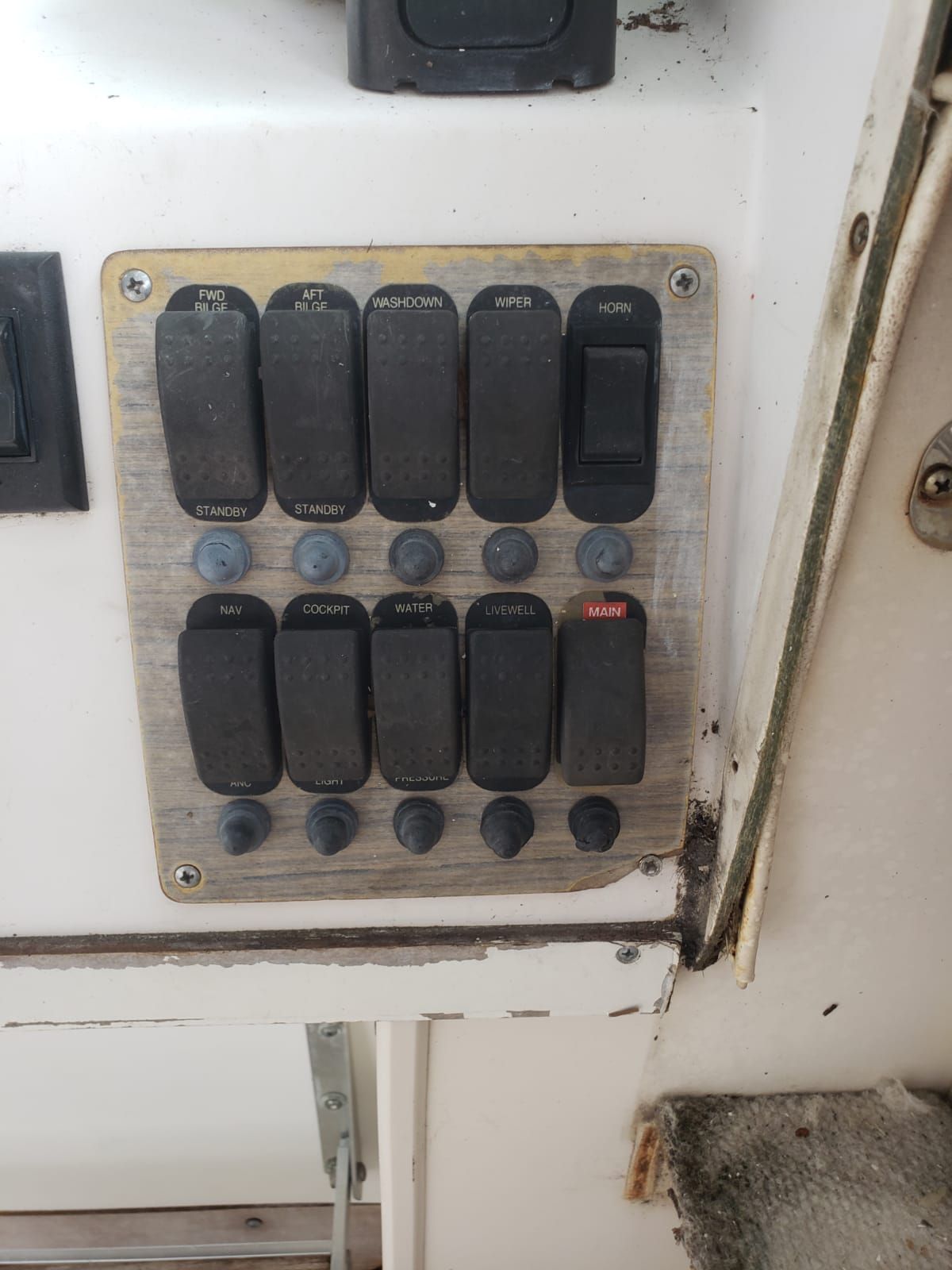A control panel with multiple toggle switches and buttons on a boat.