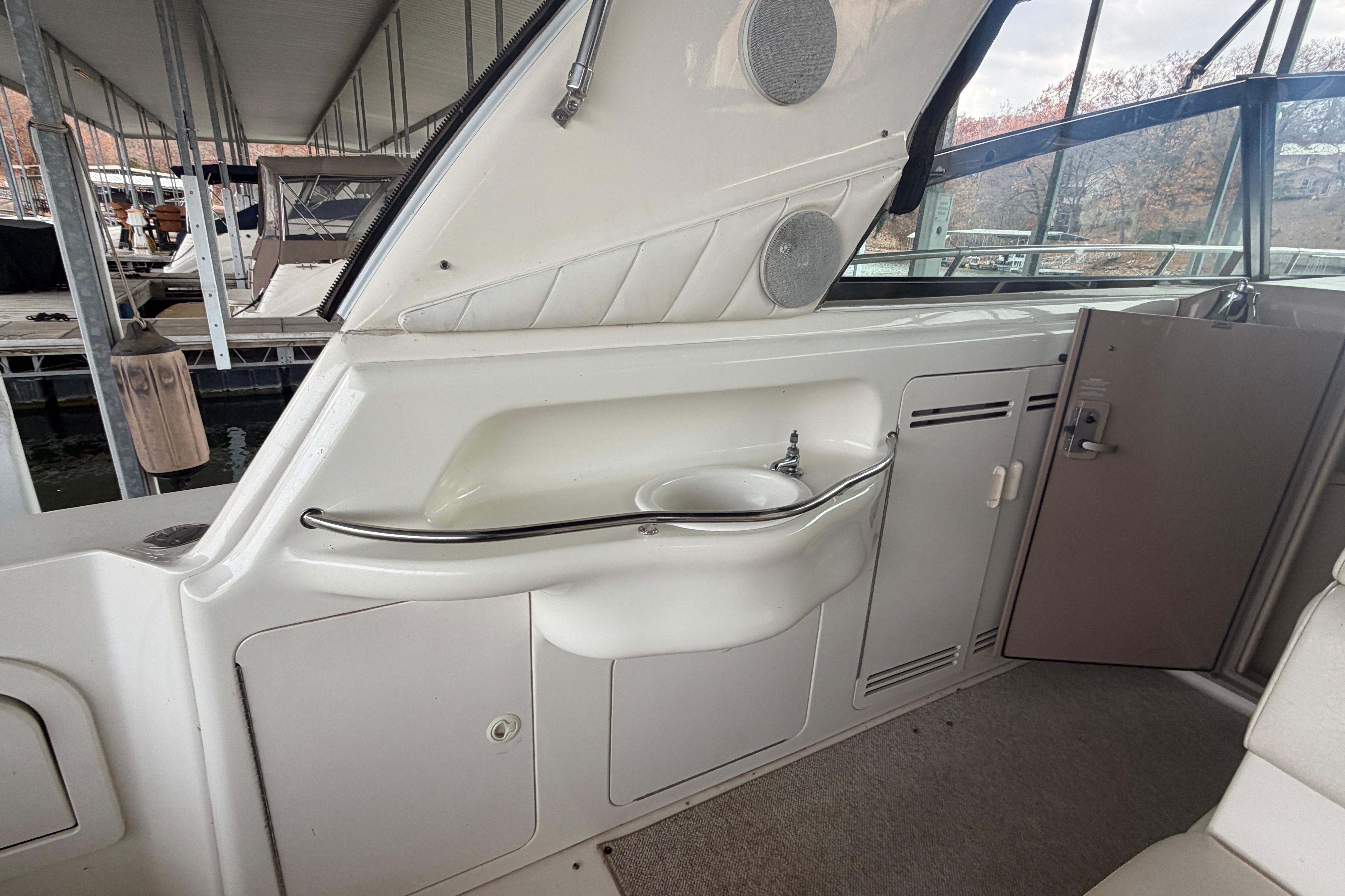 1999 Sea Ray 400 Sundancer interior with sink and storage compartments.
