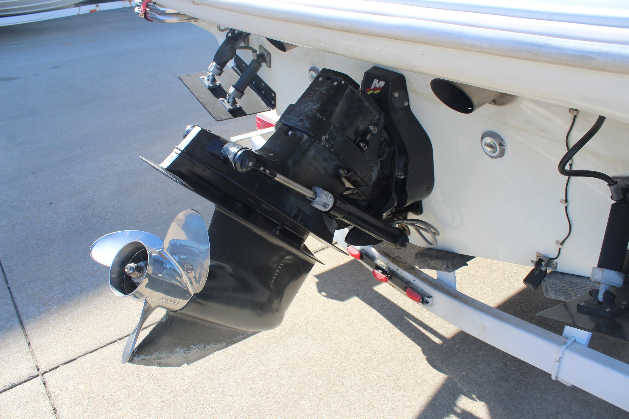 1996 Baja 232 boat with a shiny propeller and outboard motor detail.