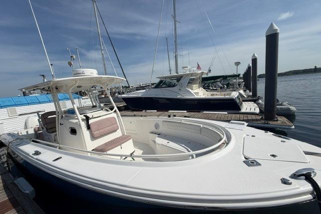 2014 Edgewater 318CC boat docked at marina under clear sky.