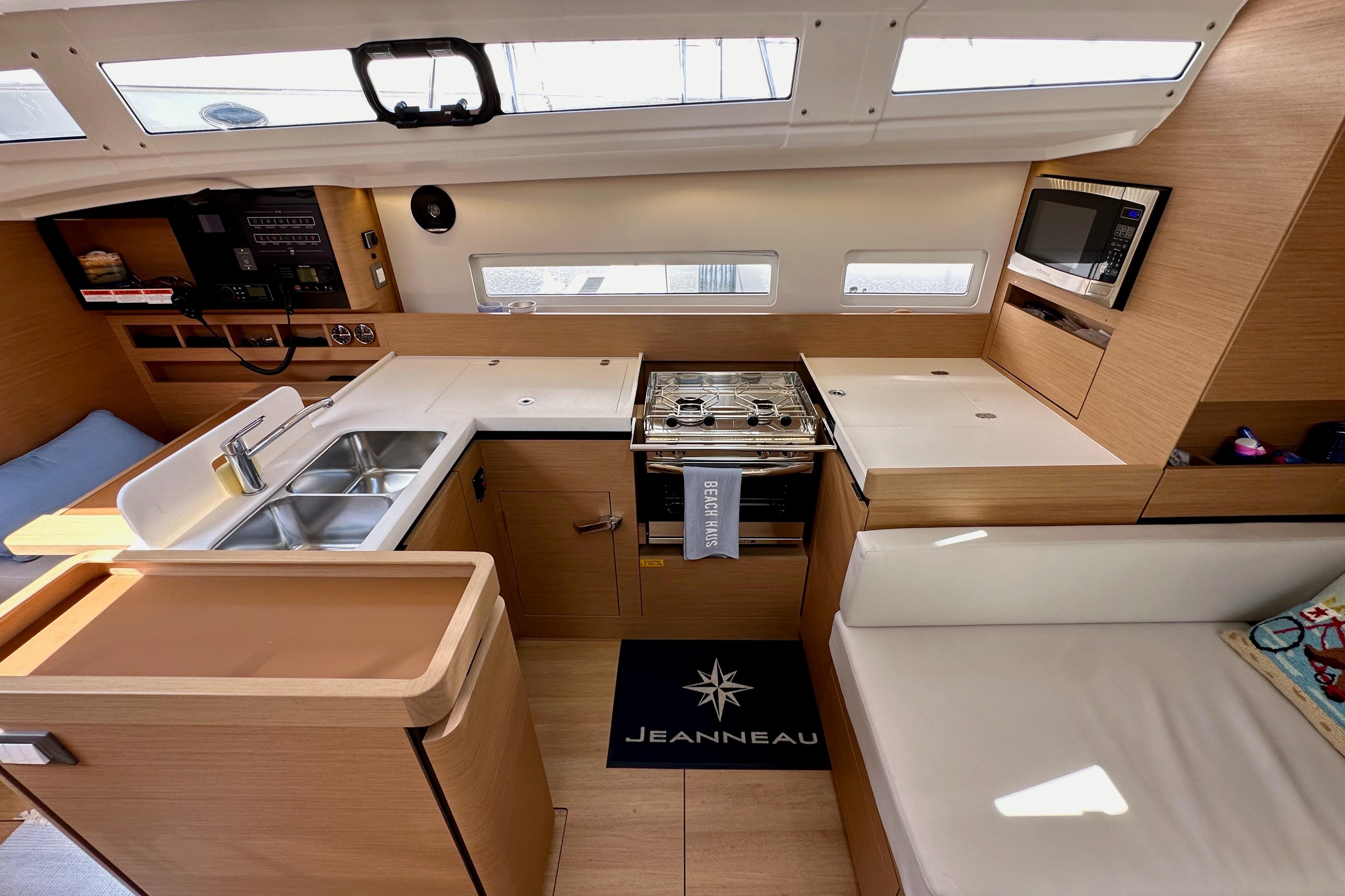 Interior of 2024 Jeanneau Sun Odyssey 410 yacht, featuring modern kitchen and seating area.