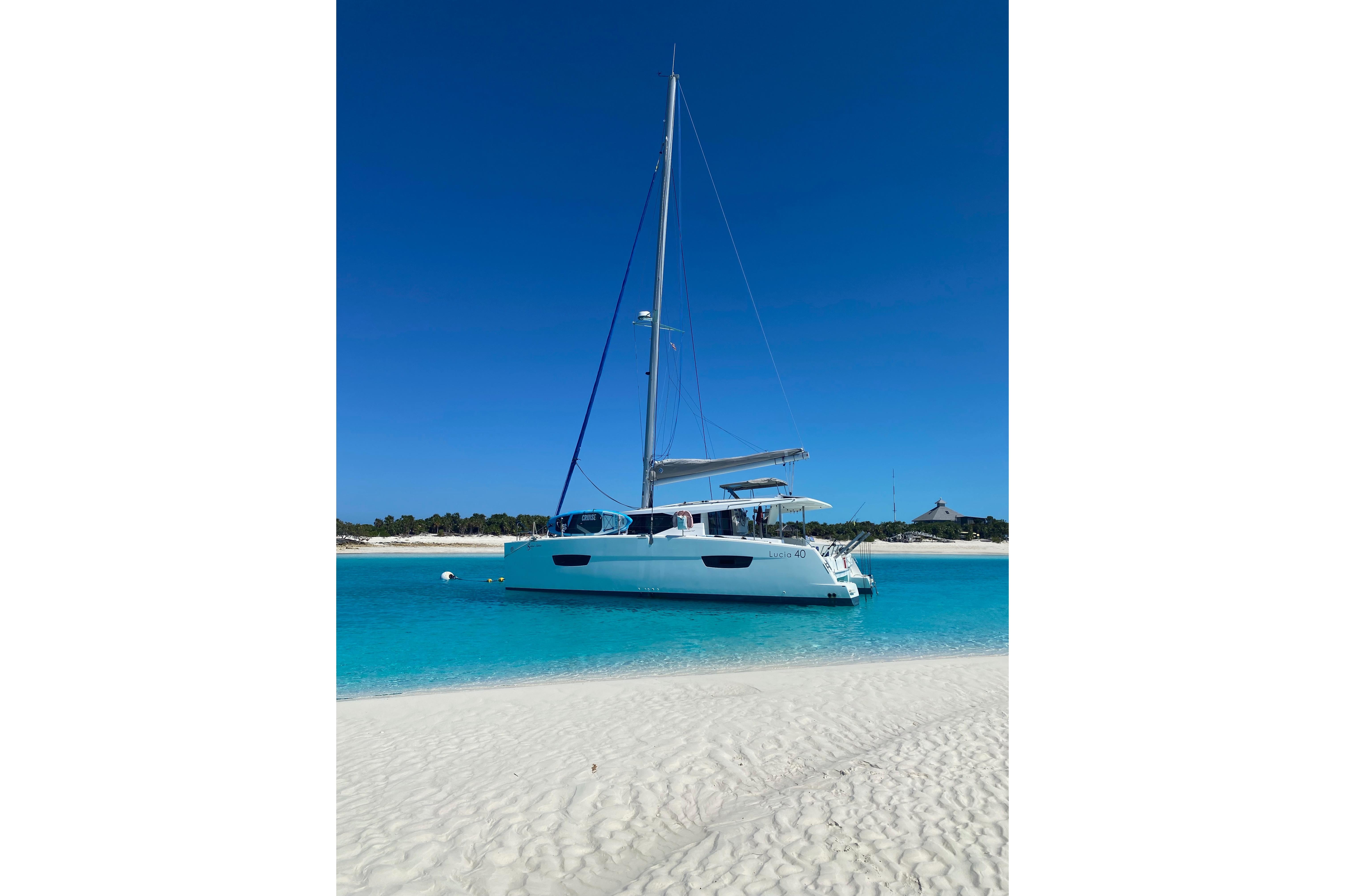 2018 Fountaine Pajot Lucia 40 catamaran anchored in clear turquoise waters.