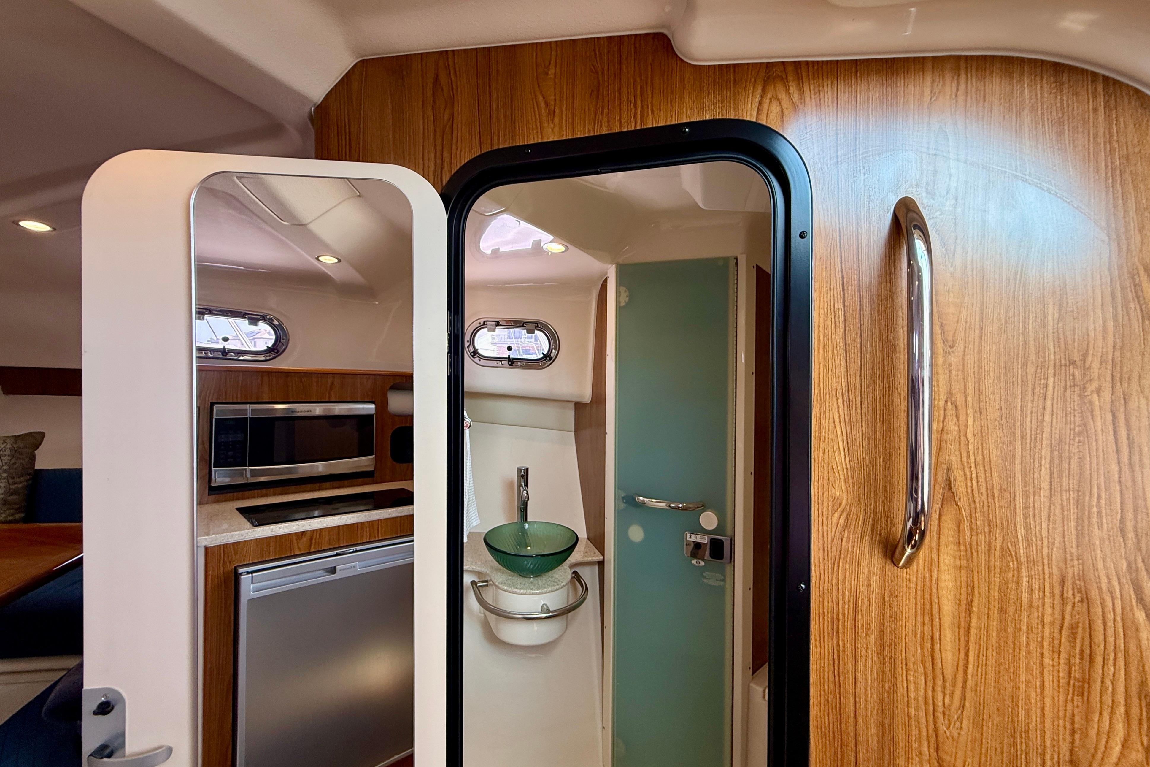 Interior of 2012 Pursuit OS 345 Offshore boat, featuring kitchenette and bathroom.