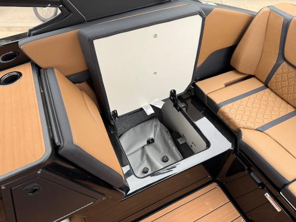 2025 Yamaha Boats 255XD interior storage compartment with tan and black seating.