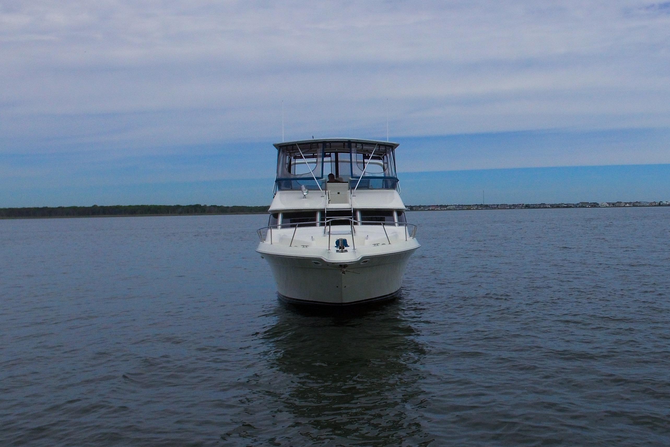 Front view of a 1993 Sea Ray 440 Express Bridge yacht on calm water.