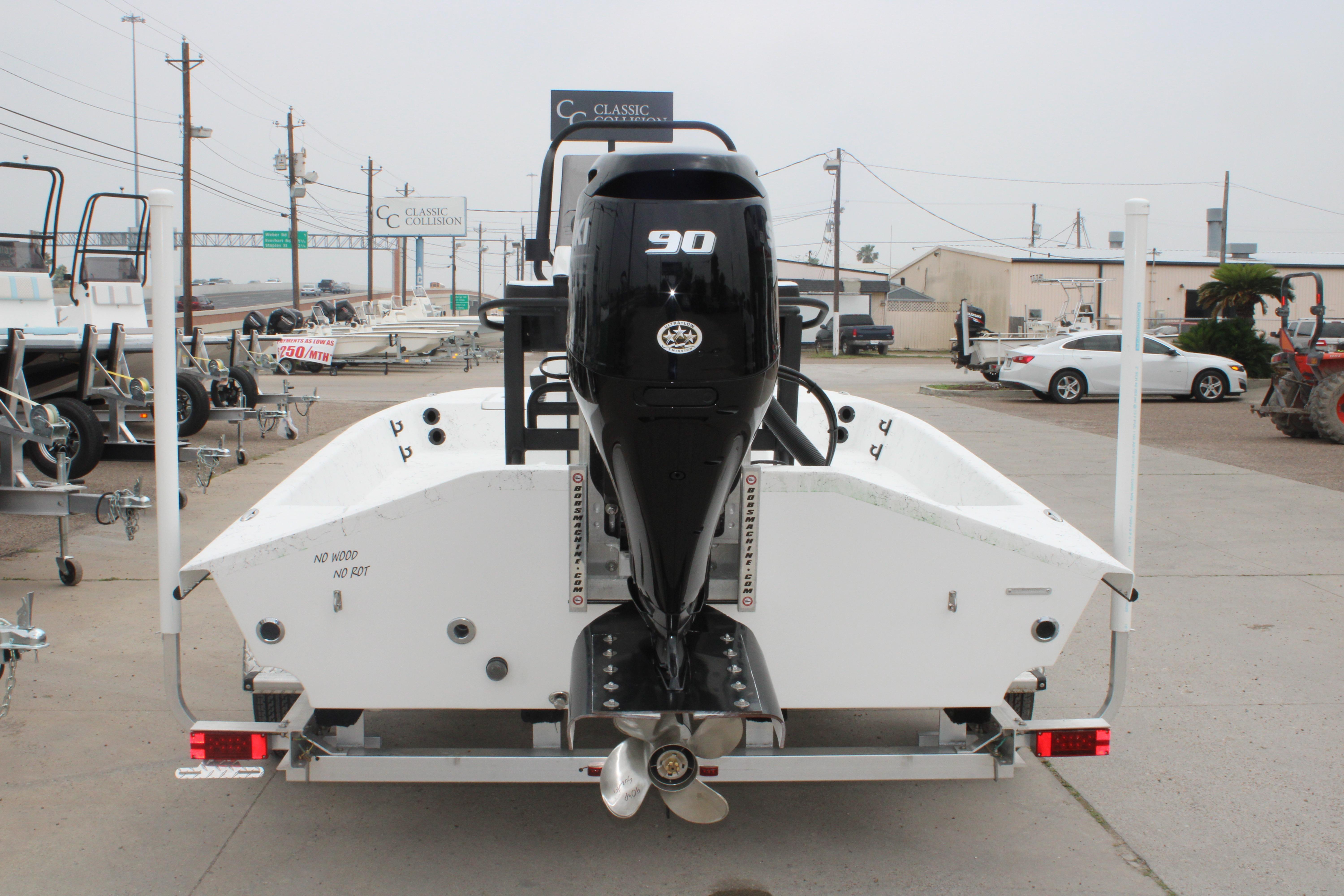 2026 Freedom Boats 16' Eagle with 90 HP engine on trailer, rear view.