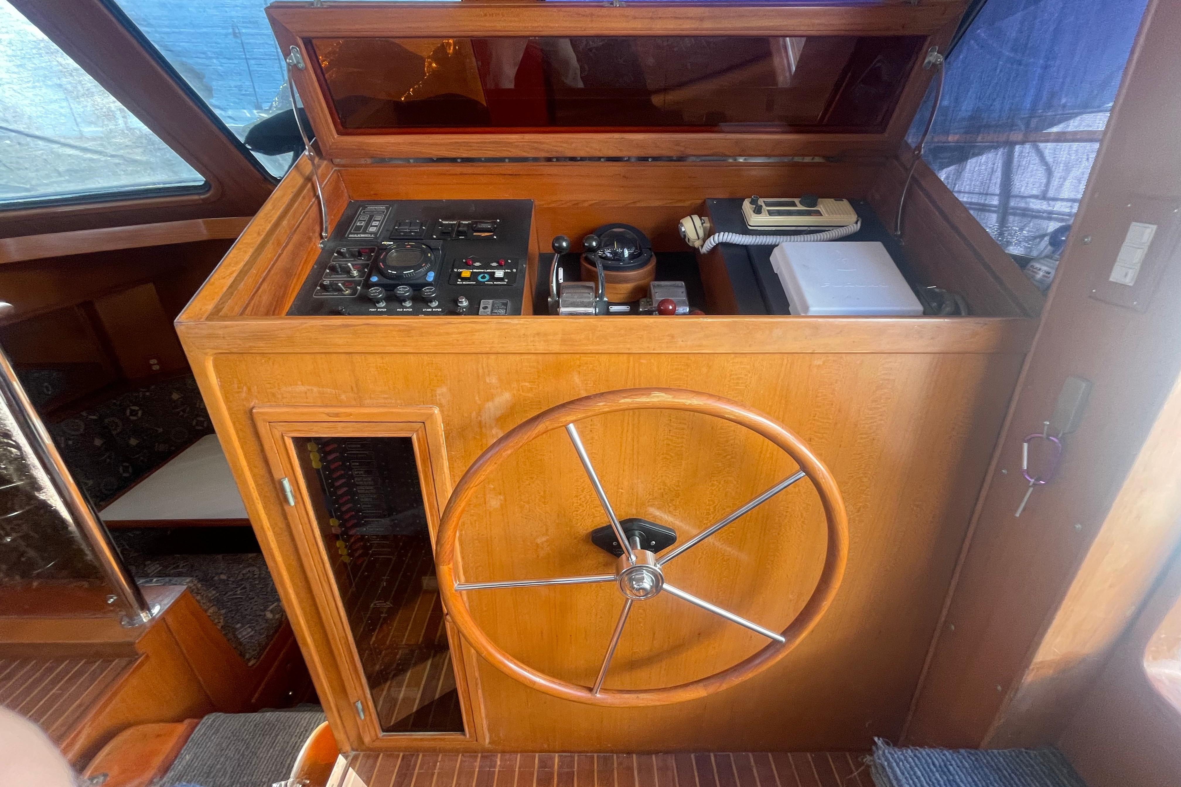 1990 Spindrift Cockpit Motoryacht helm with wooden wheel and control panel.