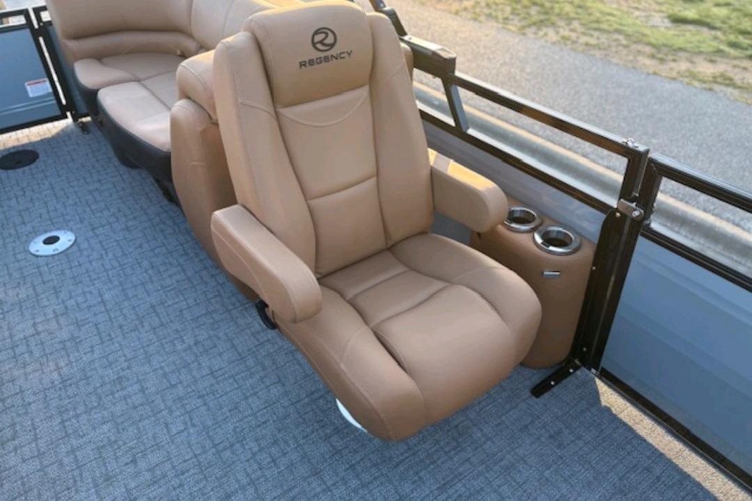 Luxurious seating on 2026 Regency 230 DL boat with cup holders and plush upholstery.