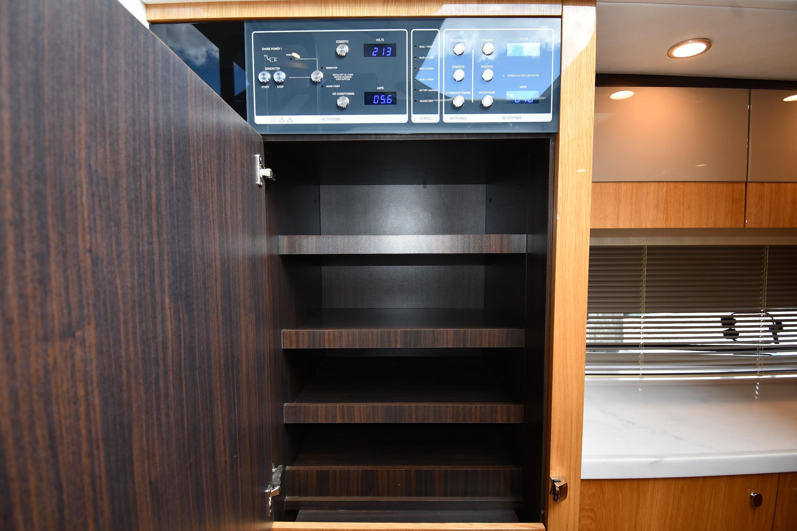 2024 Fairline G50 Targa yacht interior with open wooden cabinet and control panel.