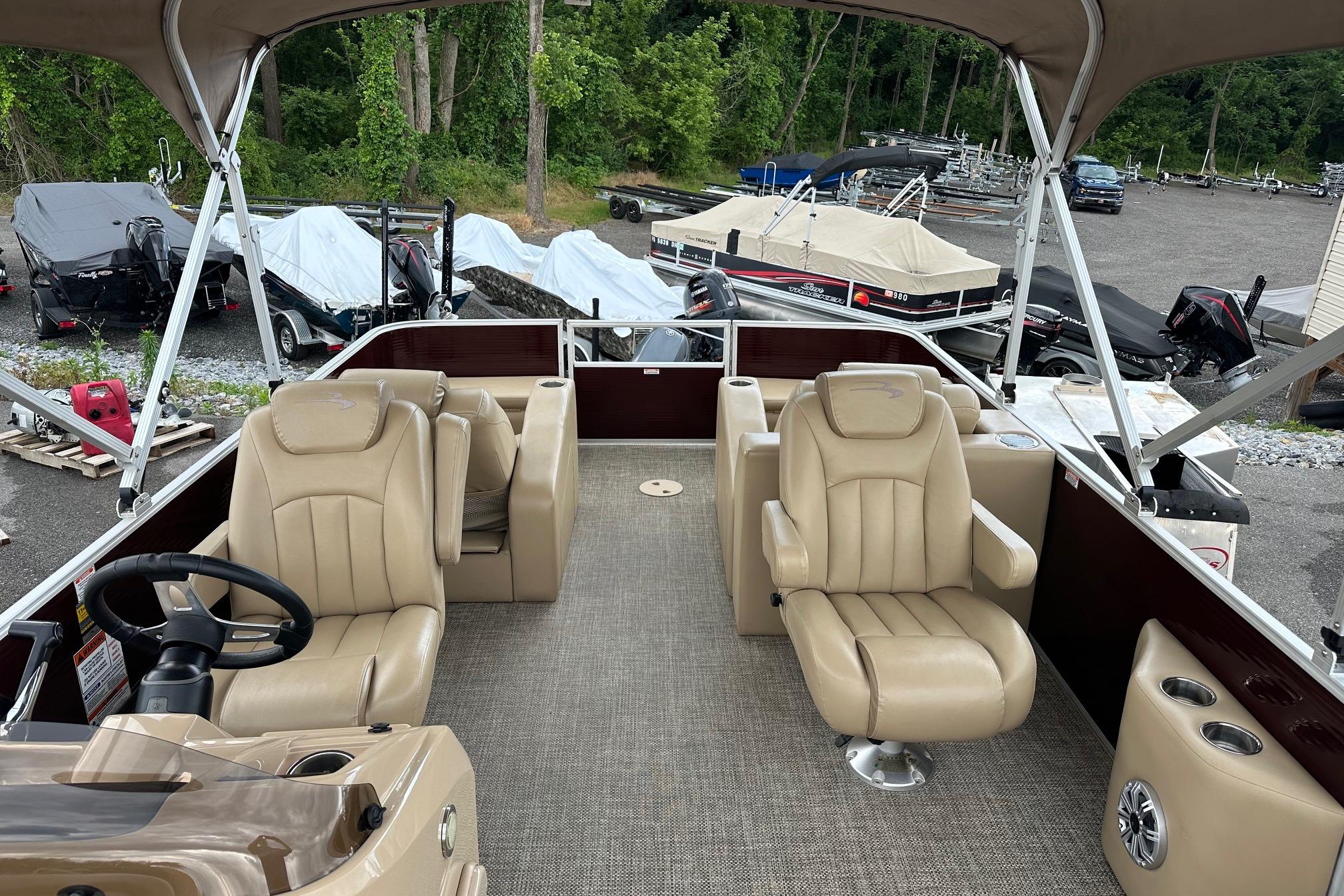 2016 Bennington 24 SCWX pontoon boat interior with beige seating and steering wheel.