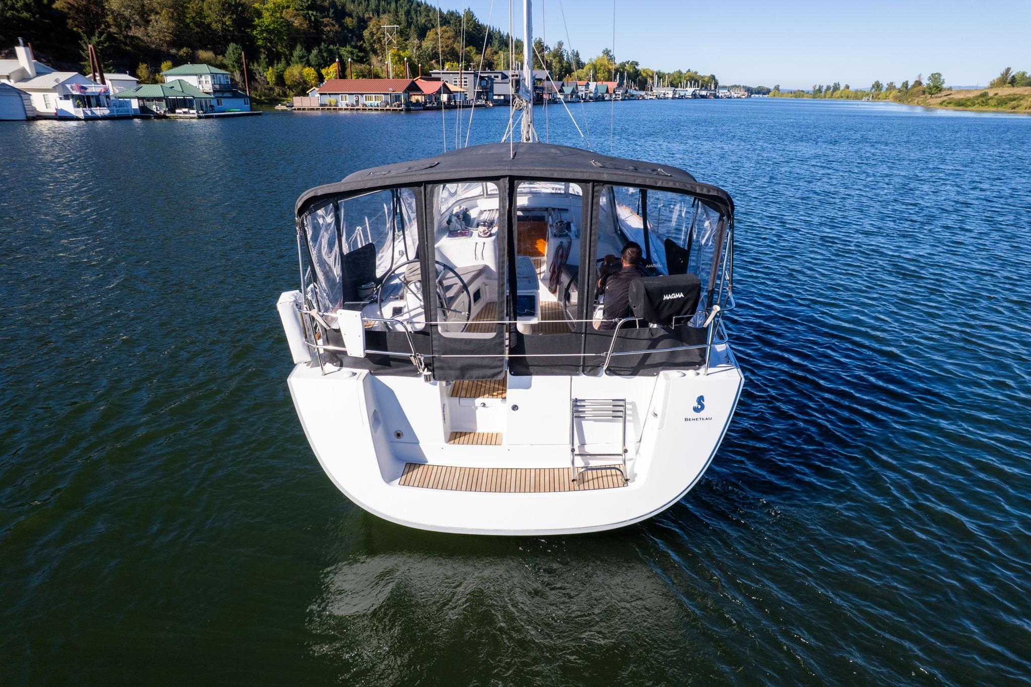 2013 Beneteau Oceanis 50 sailboat on calm water, rear view with covered cockpit.