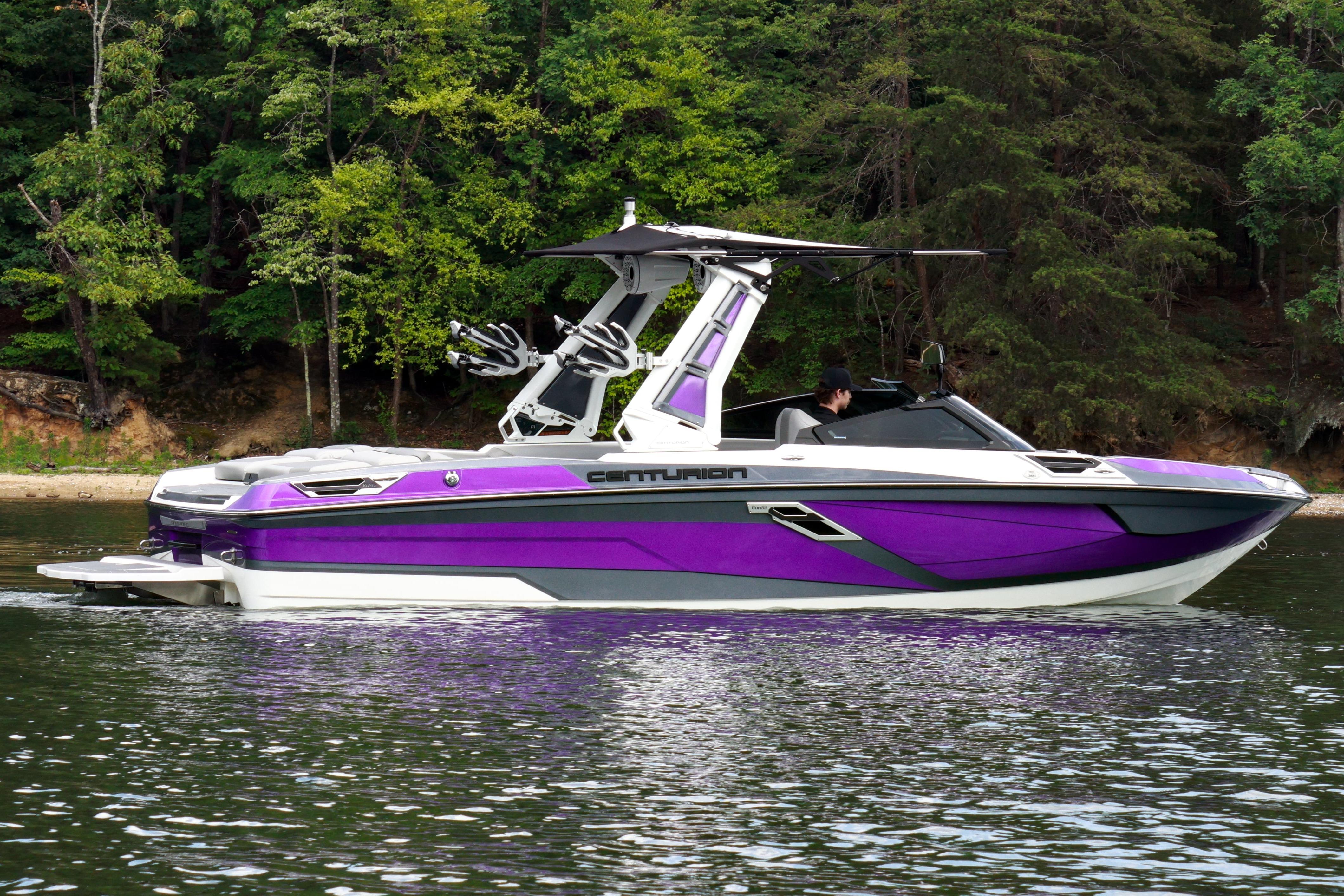 2022 Centurion Ri245 boat in vibrant purple on a serene lake with forest backdrop.