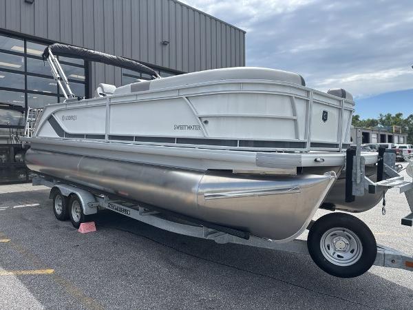 2025 Godfrey SWEETWATER 2286 SFL pontoon boat on trailer, parked outdoors.