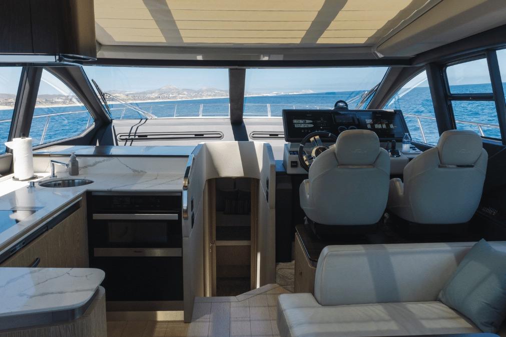 Luxurious interior of 2020 Azimut 60 yacht with modern helm and kitchen area.