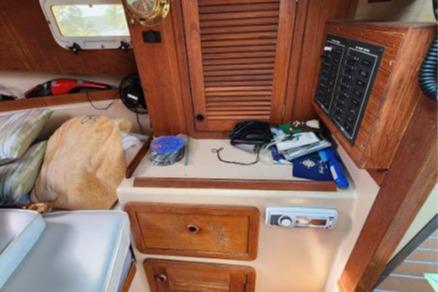 Interior of a 1985 Wasque Down East Cruiser with wooden cabinetry and nautical equipment.