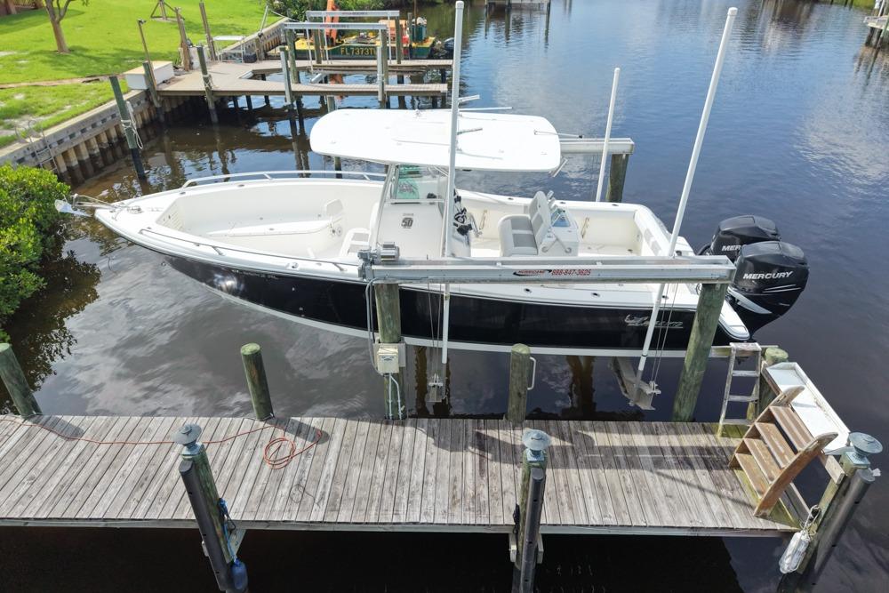 2018 Mako 284 Center Console boat docked with twin Mercury engines.