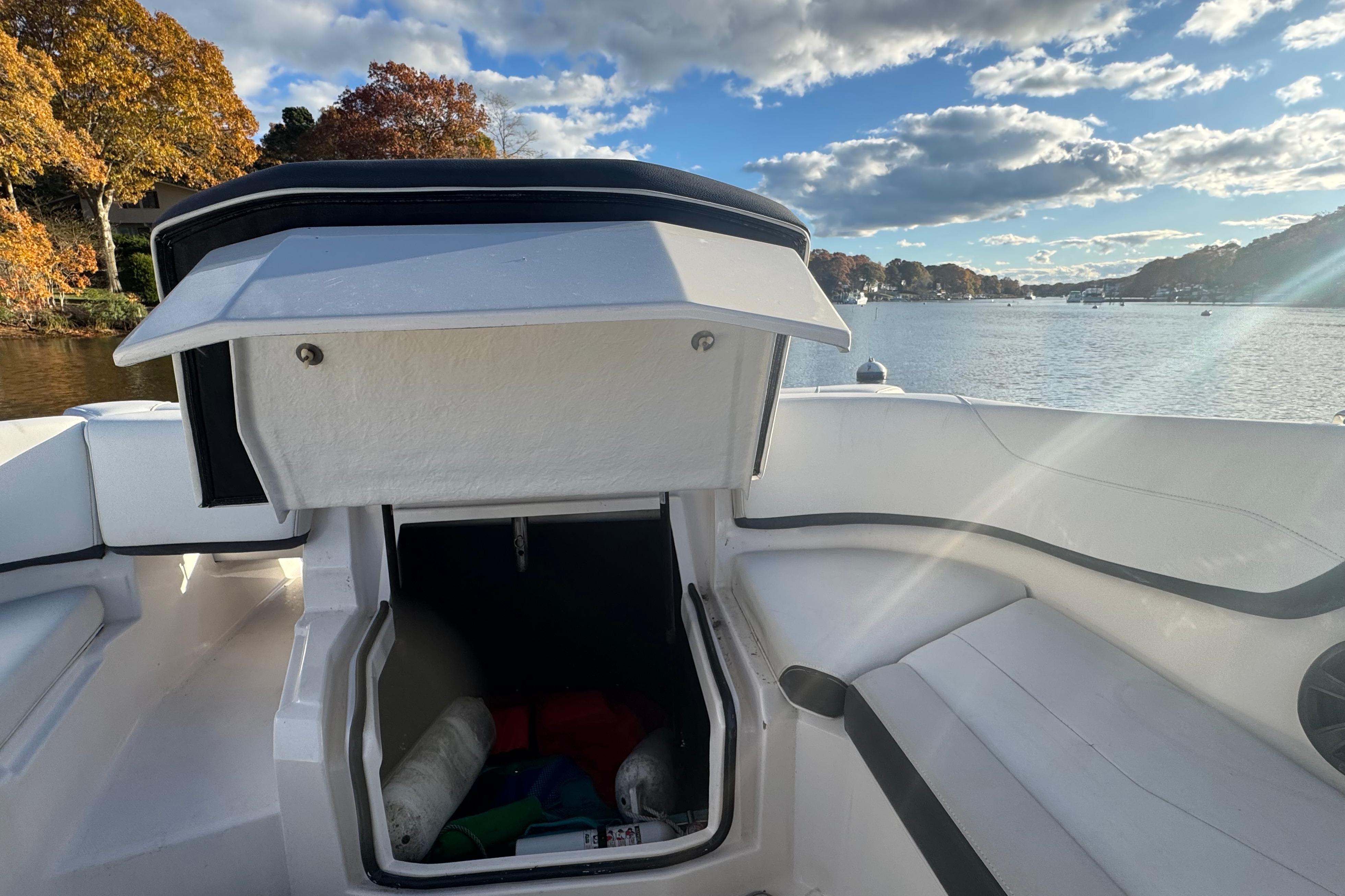 2017 Regal 23 OBX boat interior with open storage compartment, scenic lake view.