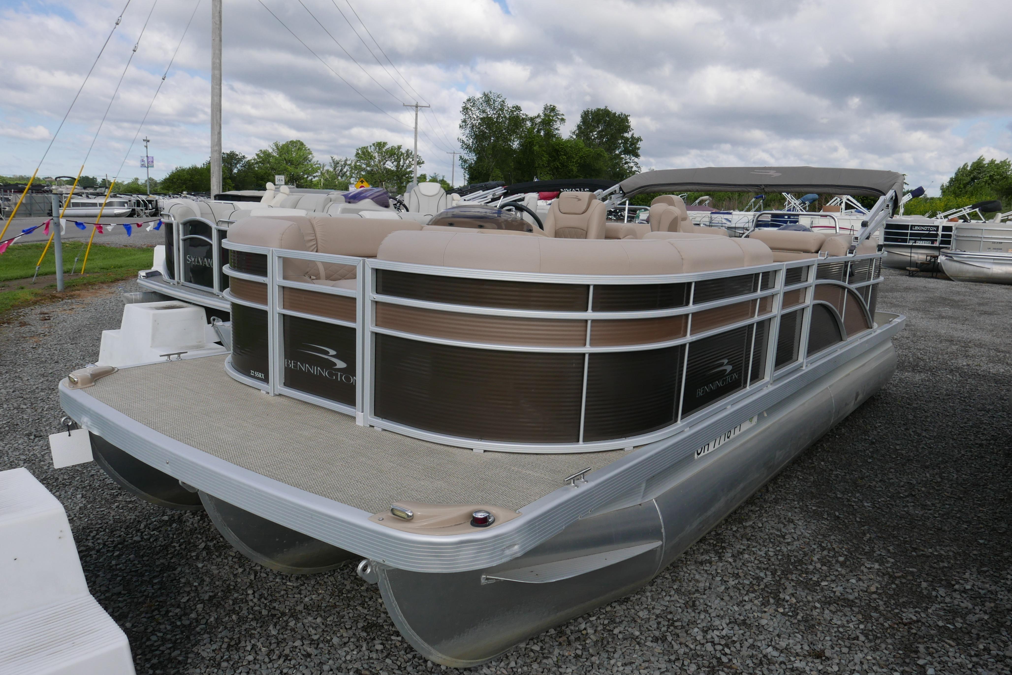 2018 Bennington 22 SSRX pontoon boat with beige seating, displayed outdoors.