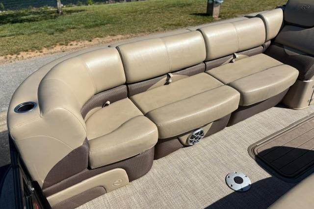 Luxurious seating on 2025 Regency 250 DL3 pontoon boat, featuring beige upholstery and cup holder.