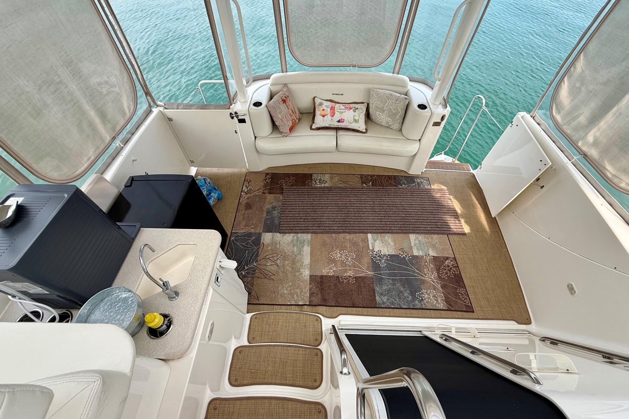 2004 Silverton 39 Motor Yacht interior with cozy seating, kitchenette, and ocean view.