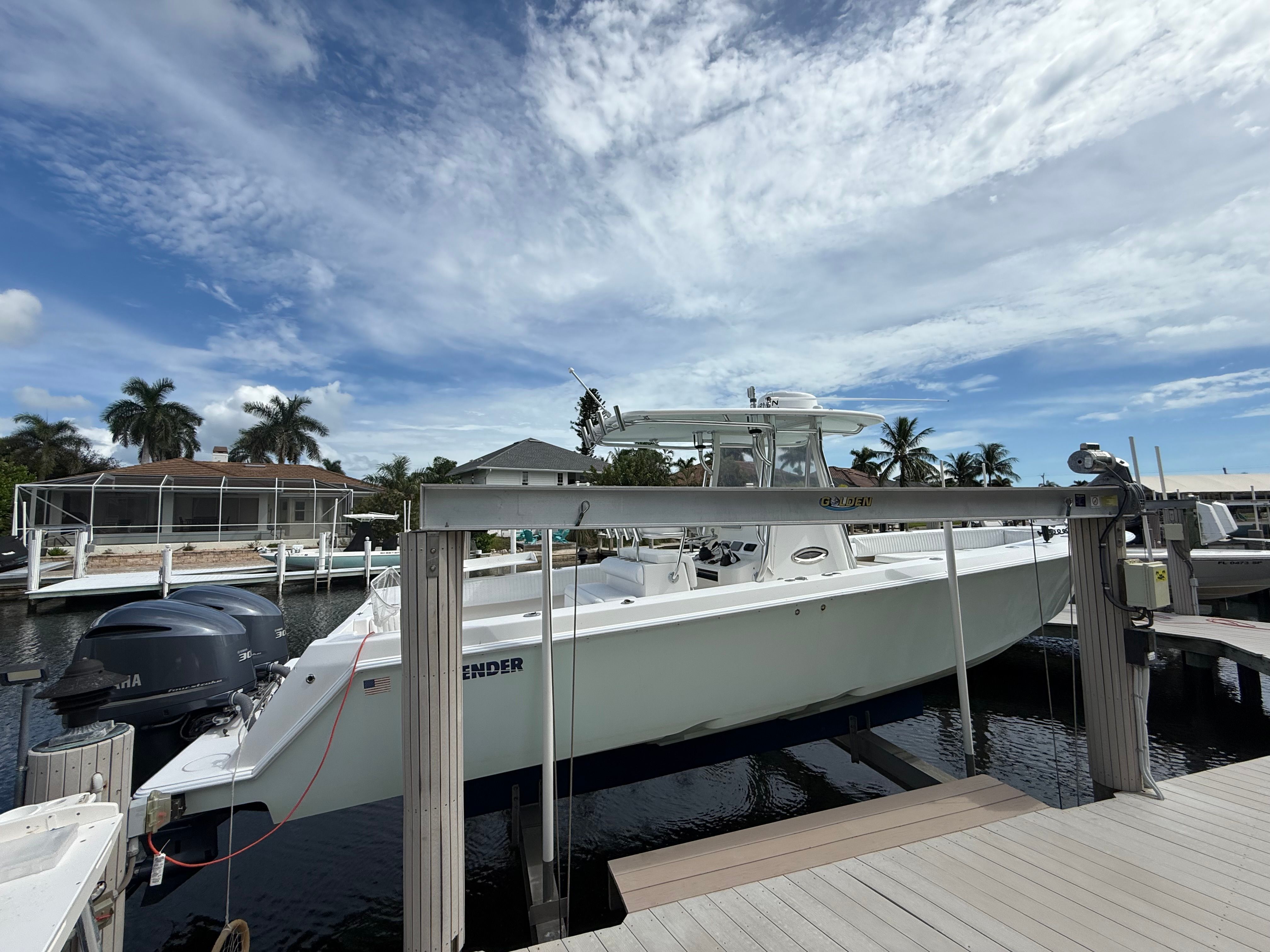 2012 Contender 32 ST boat docked under a blue sky.