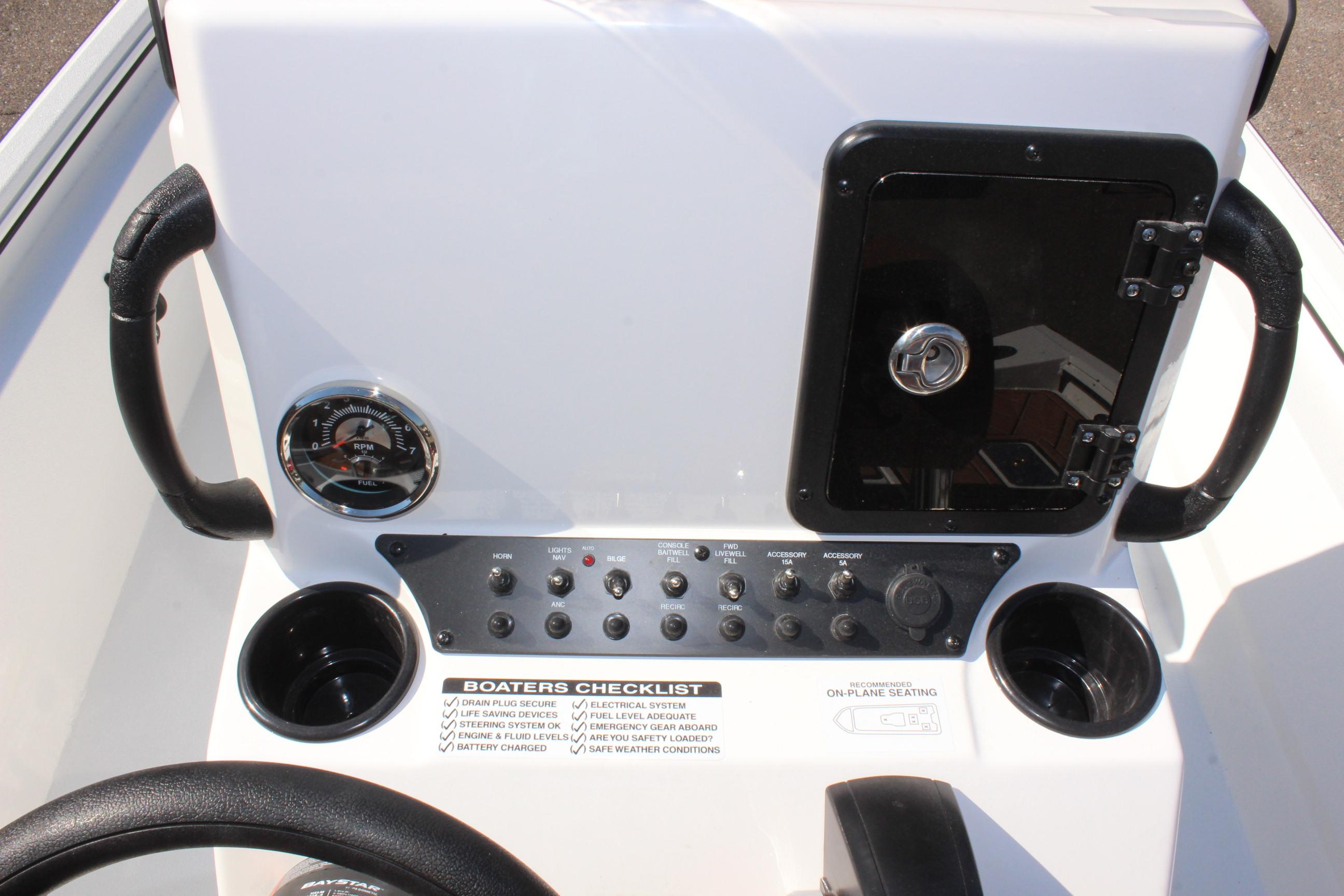 Avid 18 Rogue CC 2025 boat console with controls, gauges, and storage compartment.
