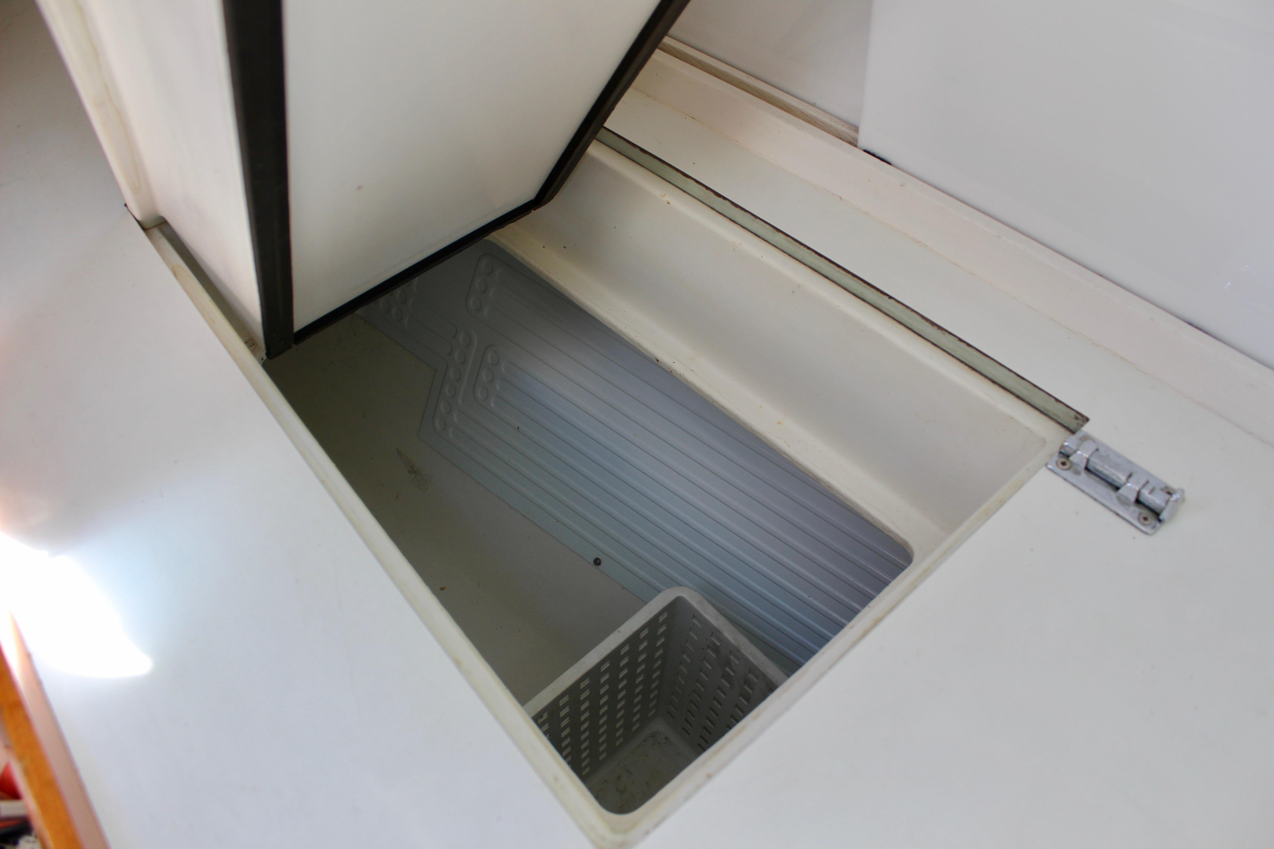 Open storage compartment on Freya 39 yacht, 1993 model, with white interior and basket.