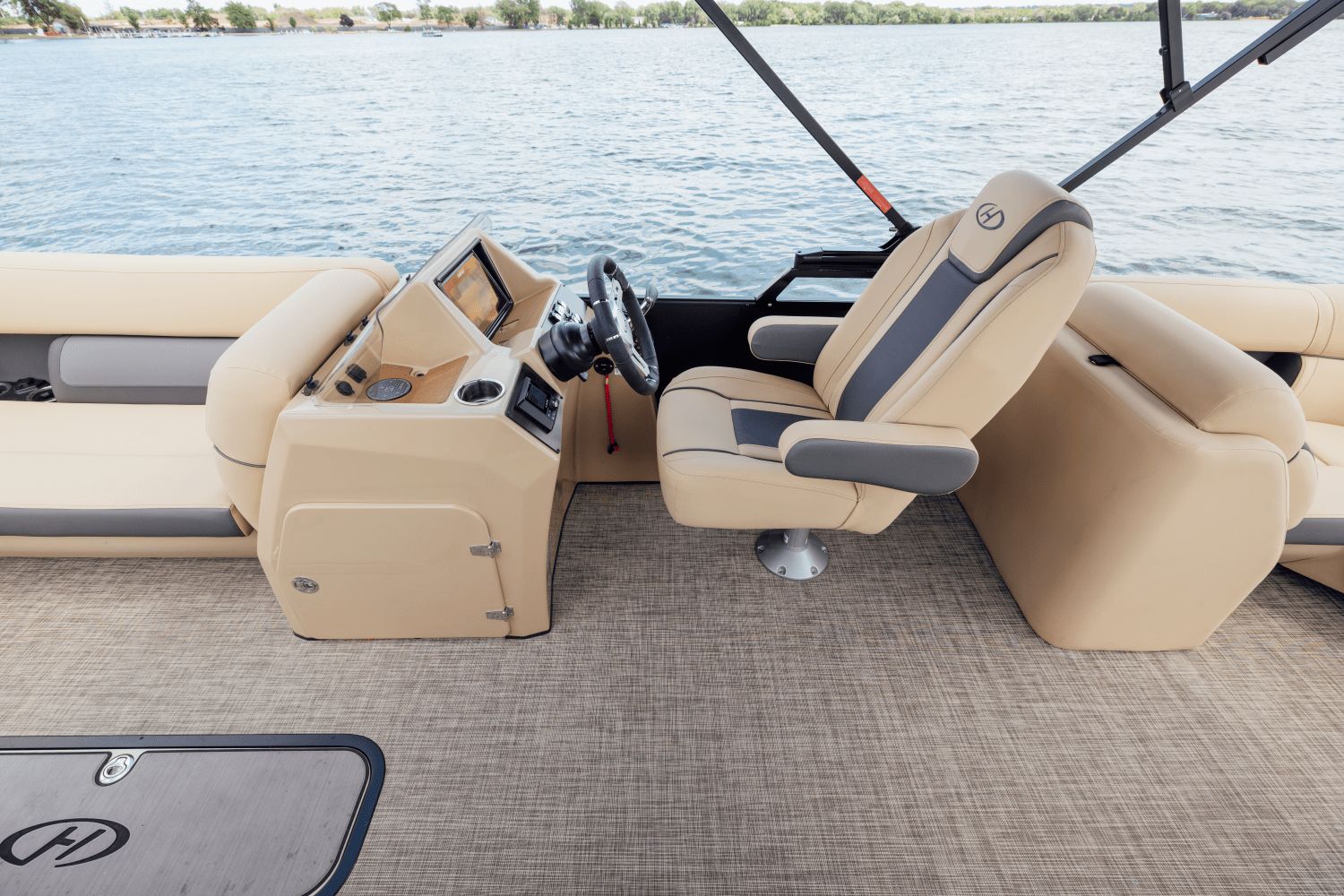 The image shows the cockpit of a 2026 Harris Cruiser 230 with beige seats and a steering wheel.