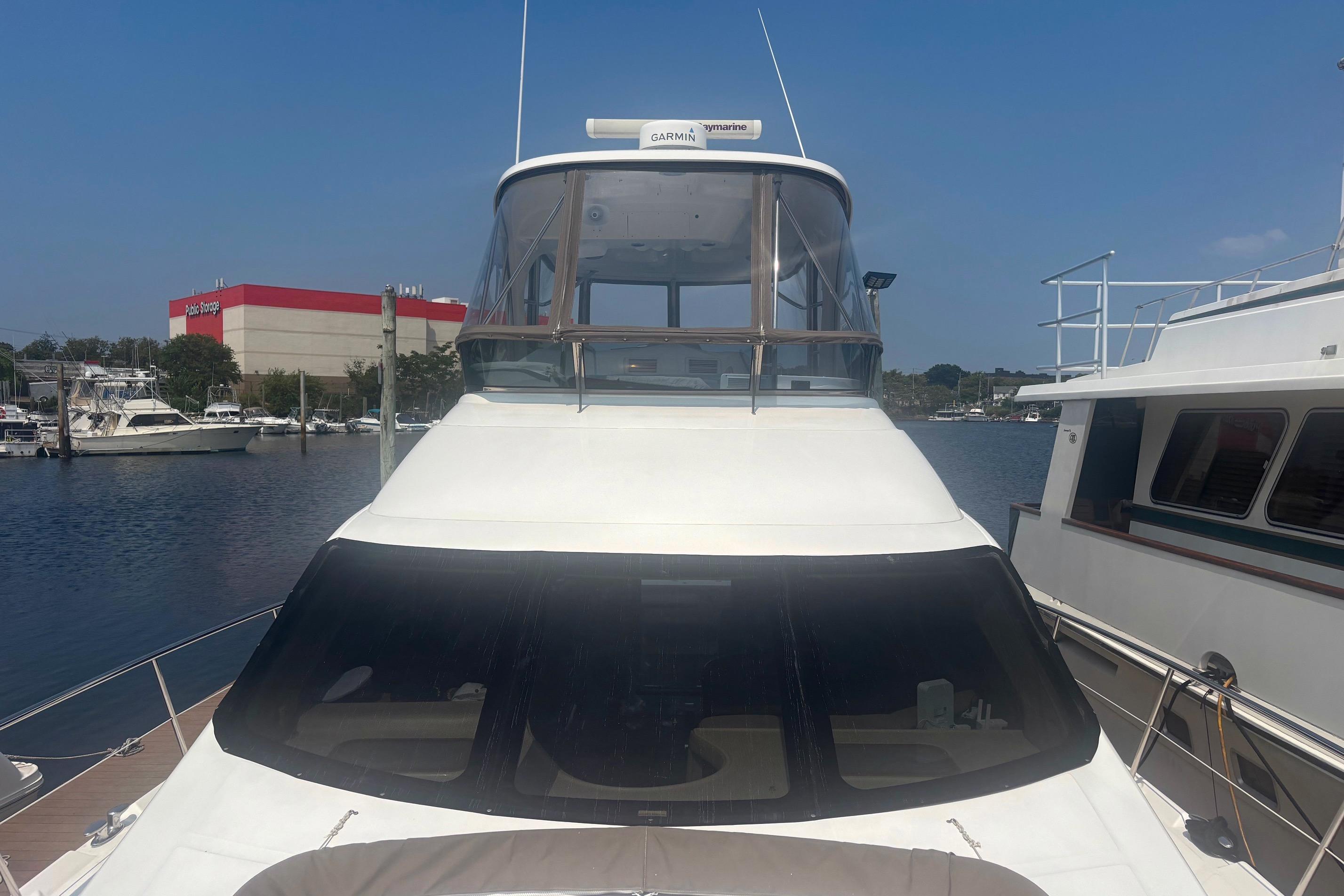 2006 Sea Ray 52 Sedan Bridge yacht docked at marina under clear blue sky.