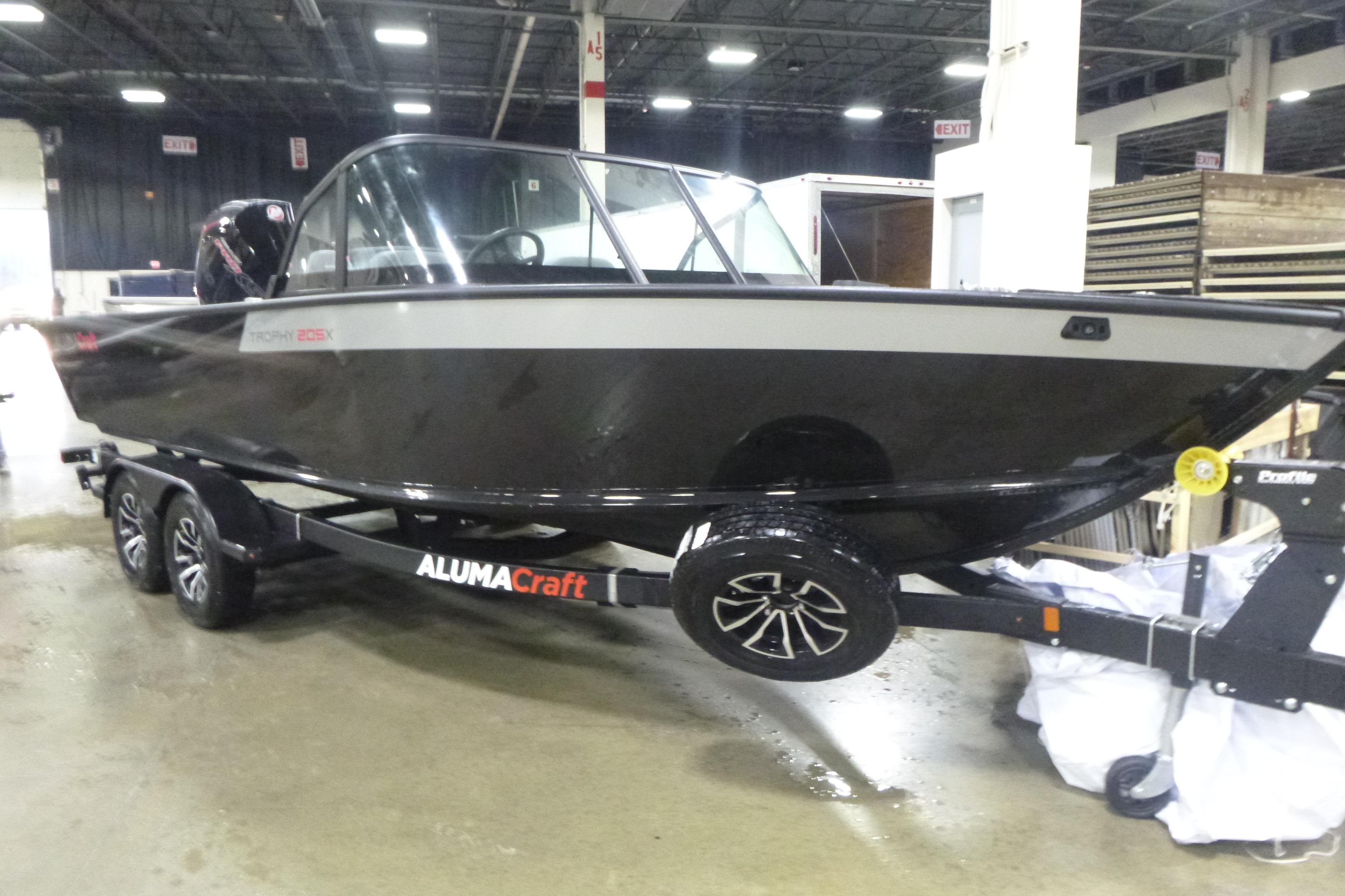 2026 Alumacraft Trophy 205X Sport boat on trailer in indoor setting.