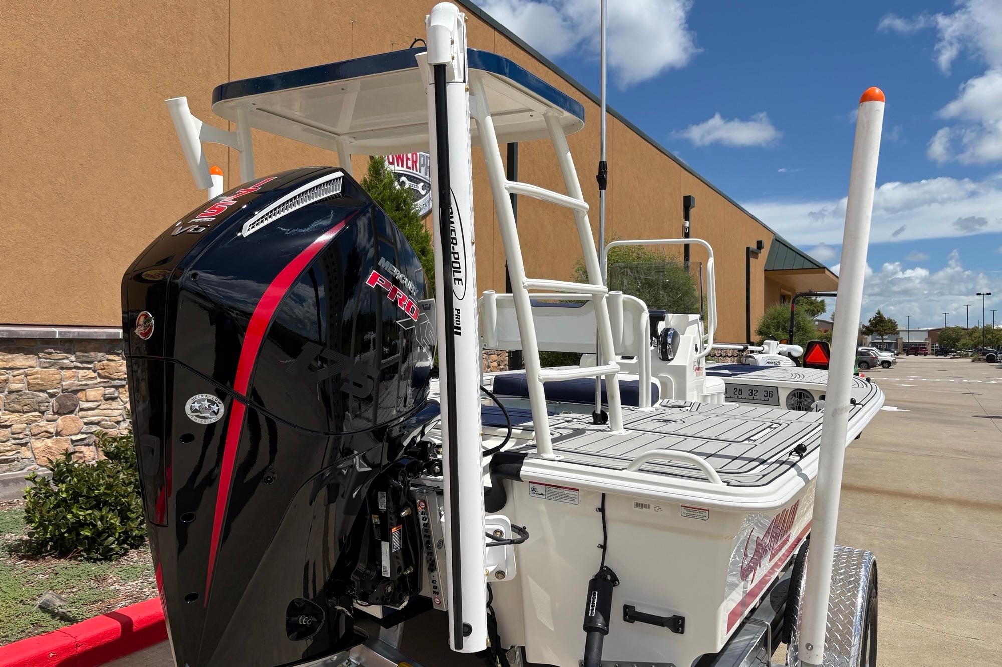 2026 Mako 18 Pro Skiff Patriot Edition with powerful outboard motor in parking lot.