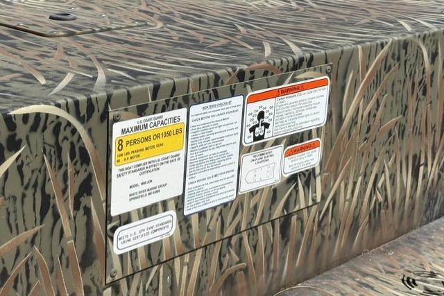 2026 Tracker Grizzly 1860 Utility boat with camouflage design and capacity warning labels.