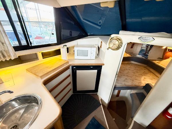 Interior of 1992 Carver Command Bridge 2828 with kitchenette and sleeping area.