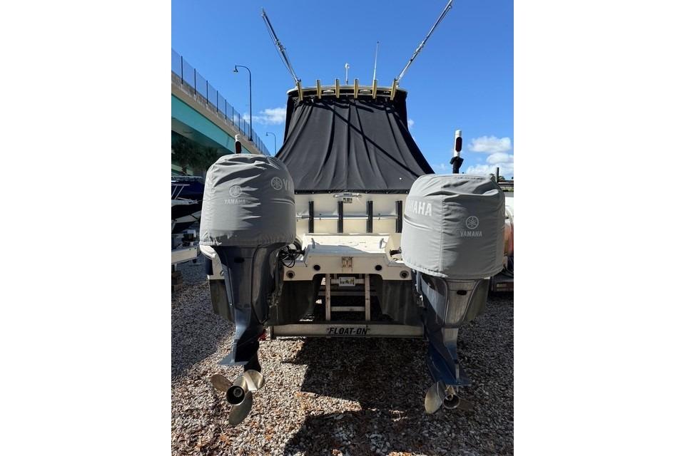 2003 World Cat 270 EC boat with Yamaha outboard motors, covered and docked.