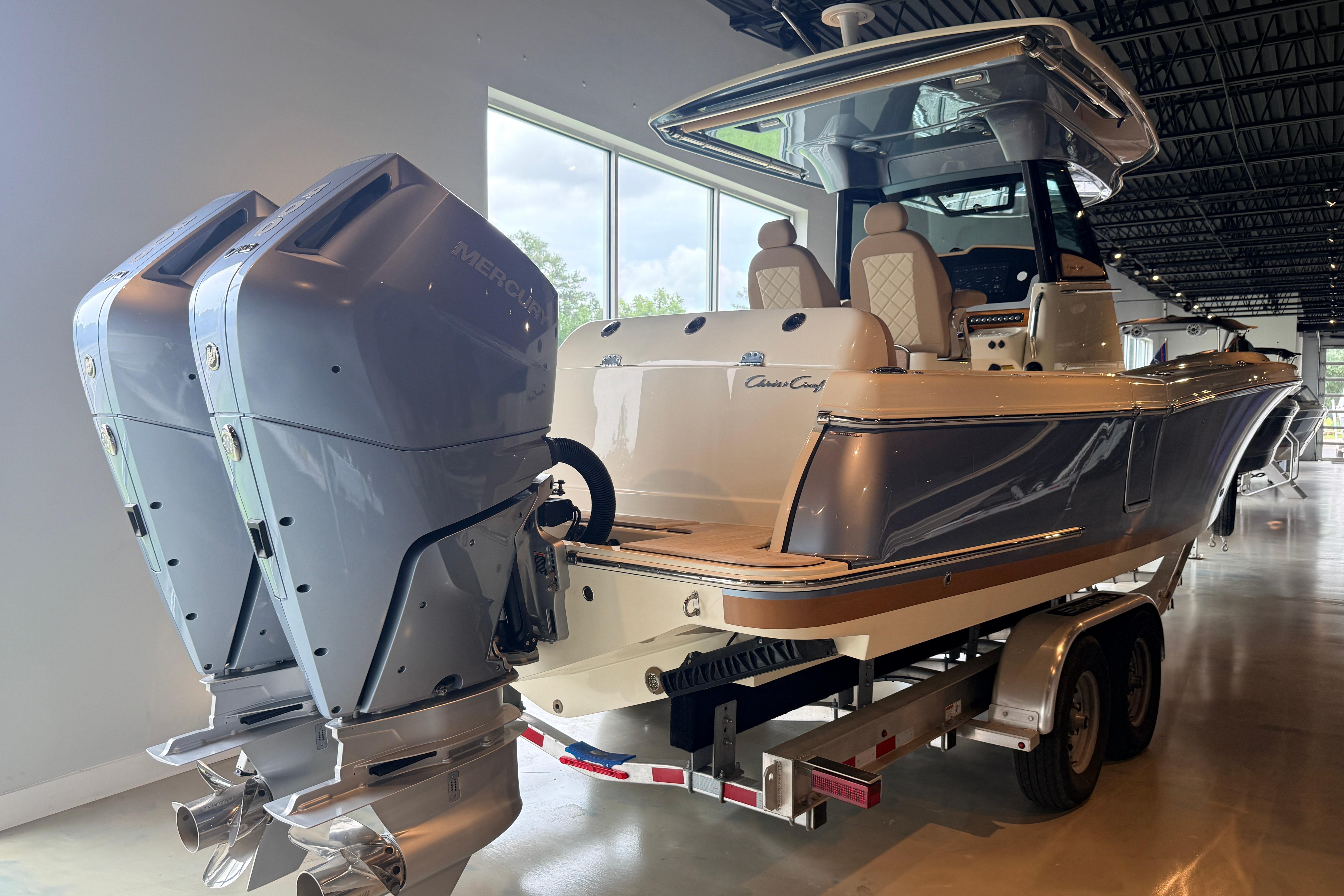 2024 Chris-Craft Catalina 30 boat with dual Mercury outboard engines on display indoors.
