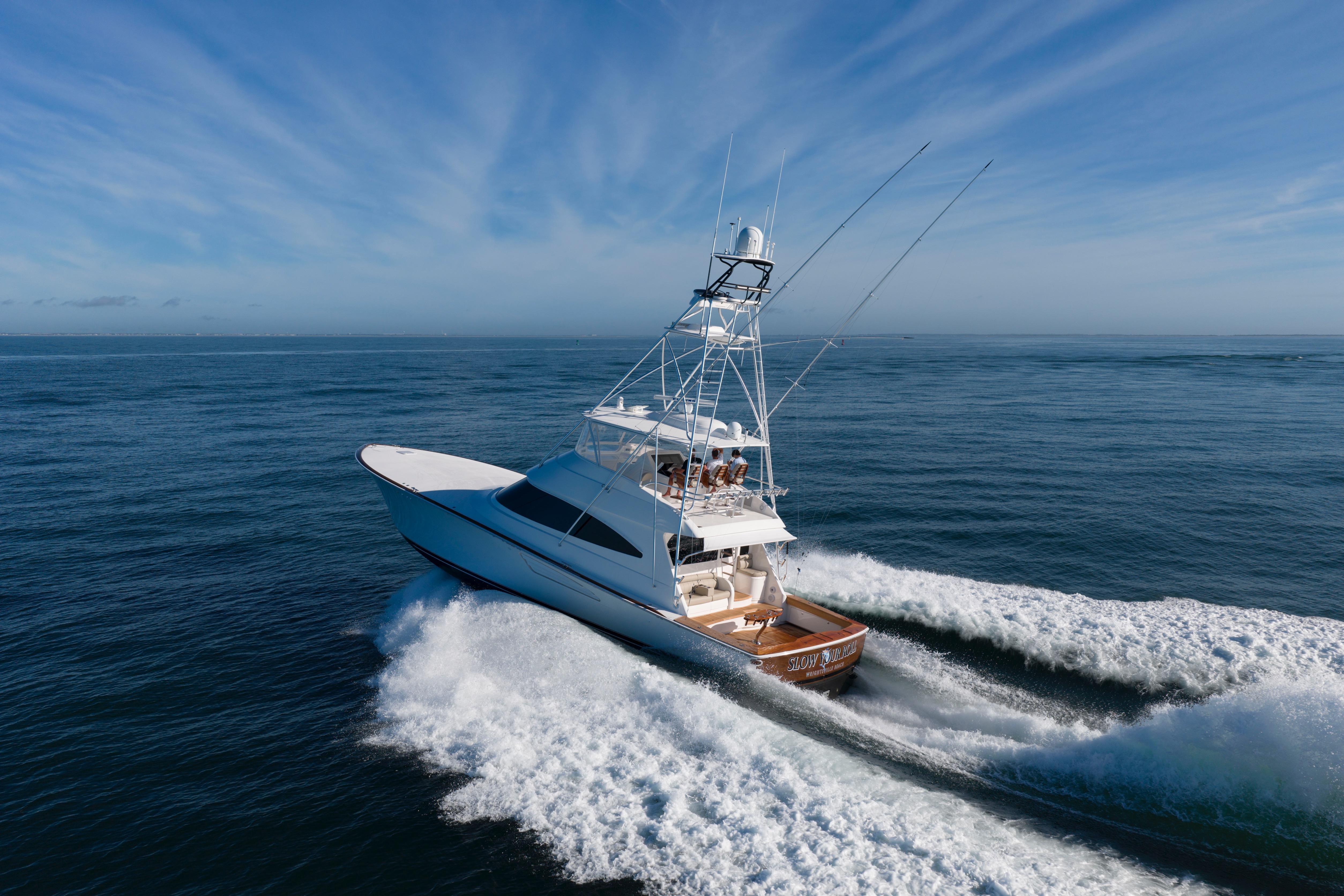2019 Viking 68 Convertible yacht cruising on open ocean under clear blue sky.